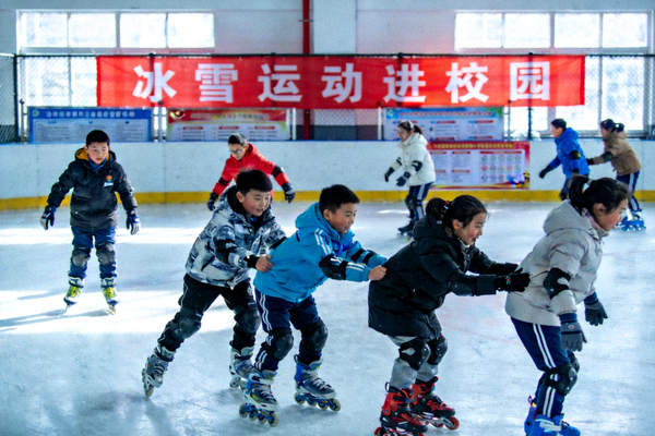 冰雪运动进校园活动现场 - 学生在冰场上练习滑行